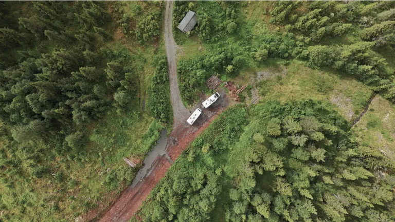 Camping-cars isolés en pleine forêt vus du ciel sur chemin de terre